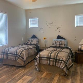 A cozy bedroom featuring twin beds with plaid bedding and minimalist decor.