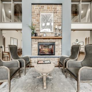 A modern living room with a cozy fireplace and elegant armchairs.