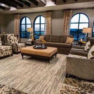A cozy living room with elegant furniture and large arched windows.