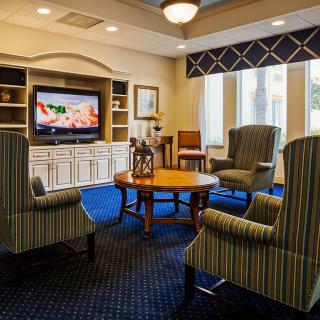 A cozy living room with armchairs, a coffee table, and a television.
