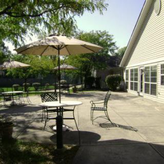 Outdoor patio area with tables, chairs, and umbrellas on a sunny day.