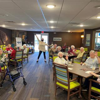 A group of seniors enjoying a social activity inside a nursing home.