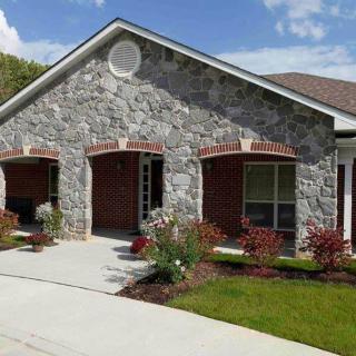 A house with a stone facade and well-maintained front yard.