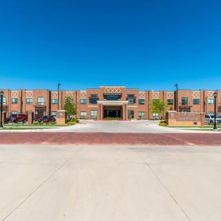A modern brick school building under a clear blue sky.