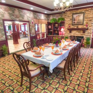 A beautifully set dining table in an elegantly decorated room with a fireplace.