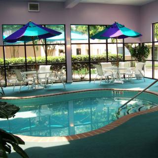 An indoor swimming pool with vibrant umbrellas and a cozy seating area.