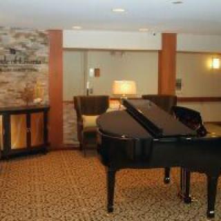 A cozy living area featuring a grand piano and a fireplace.