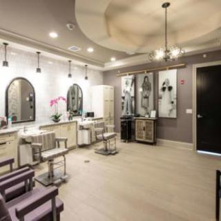 A modern salon interior with stylish chairs and mirrored hair stations.