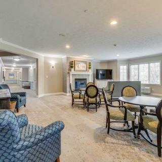Spacious and elegantly furnished living room with a central fireplace and ample seating.