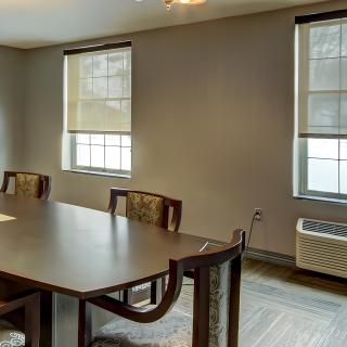 A well-lit conference room with a large table and chairs.