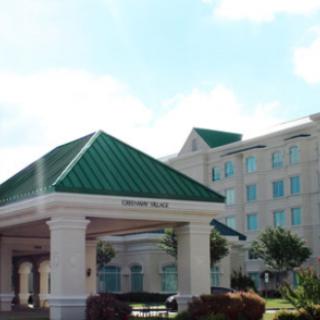 A hotel building with a green roof and an entrance area, captured during the daytime.