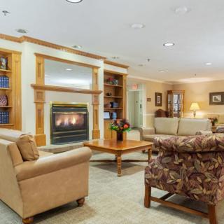 A cozy living room featuring a fireplace, comfortable seating, and built-in bookshelves.