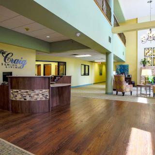 A modern reception area with wood flooring and comfortable seating.