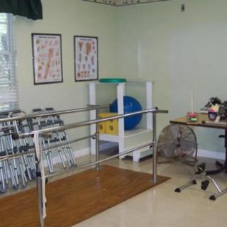 A physical therapy room equipped with parallel bars and rehabilitation tools.