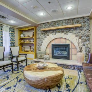 A cozy living room with a rustic fireplace and elegant seating arrangement.