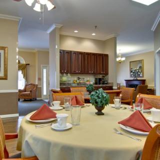 A beautifully decorated dining room with a table set for a meal, featuring warm tones and elegant furnishings.