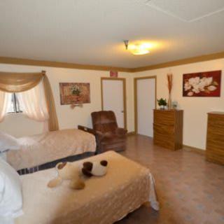 A cozy bedroom with two beds, an armchair, and elegant decor.