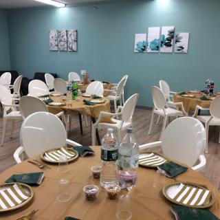A well-set dining area showcasing modern decor with green walls and elegantly arranged tables.