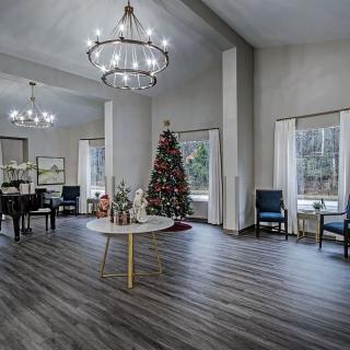 A modern lobby decorated with a Christmas tree and chandeliers.