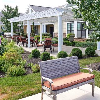 A beautifully landscaped garden with seating areas and a pergola.