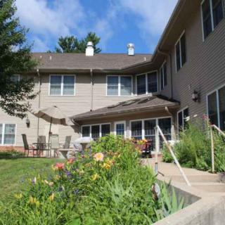A two-story house with a patio and a landscaped garden in the backyard.