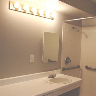 A well-lit bathroom with a mirror and sink.