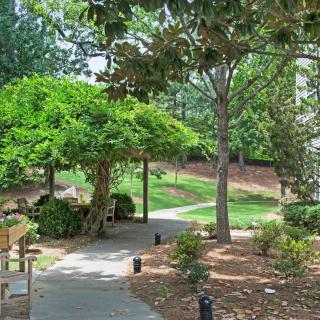 A serene garden pathway with benches and lush greenery.