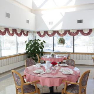 A bright and inviting dining room with elegantly set tables and large windows.