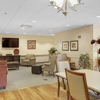 A comfortable lounge area with various seating options, a television, and decorative artwork.