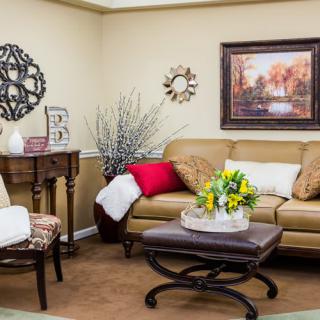 Cozy living room with a leather sofa, decorative cushions, and warm-toned artwork.