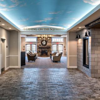 A spacious lobby with a painted sky ceiling, elegant chandelier, and comfortable seating area.