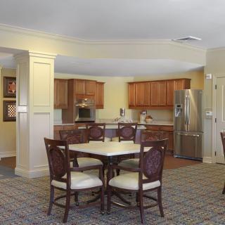 A modern kitchen and dining area with warm lighting and wooden cabinets.