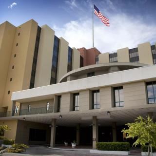 A hospital building with an American flag flying above.