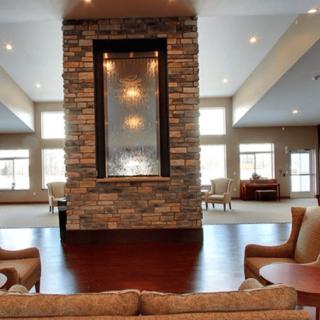 A modern living room with a stone fireplace and comfortable seating.