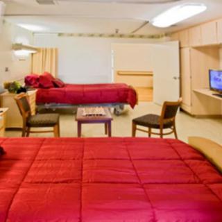 A hospital room with two twin beds and a seating area, designed for patient comfort.