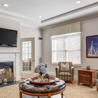 A cozy living room with elegant decor, featuring a fireplace, TV, and a comfortable armchair.