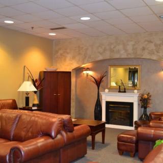 A cozy living room with leather furniture and a fireplace.
