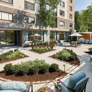 A beautifully landscaped courtyard with outdoor seating and gardens in an apartment complex.