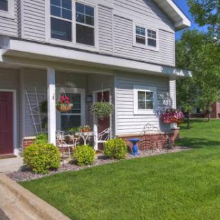 A charming two-story house with a well-kept front yard and inviting porch.