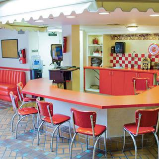 A retro-style diner with red chairs and a counter for seating.