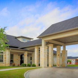 A modern residential building with a covered entrance and stone exterior.