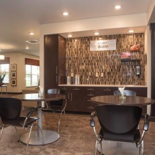 A modern dining area with a kitchenette and sleek furniture.