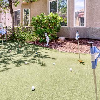 Backyard putting green with flags and golf balls near a house.