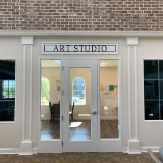 Entrance to an art studio with glass doors and windows.