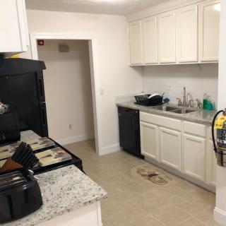 A modern kitchen with white cabinetry and appliances.