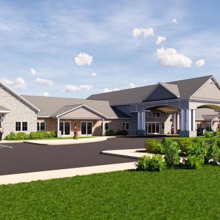 A modern building with a spacious driveway and well-maintained landscape under a cloudy sky.