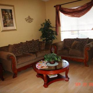 A cozy living room with a sofa set and a round wooden coffee table.
