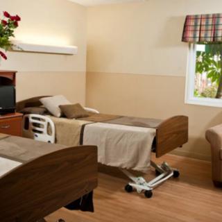 A well-lit hospital room with twin beds and a pleasant decor.