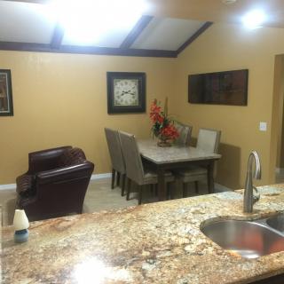 A modern kitchen and dining area with granite countertops and stylish decor.
