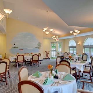 An elegant dining room with neatly arranged tables and soft lighting.
